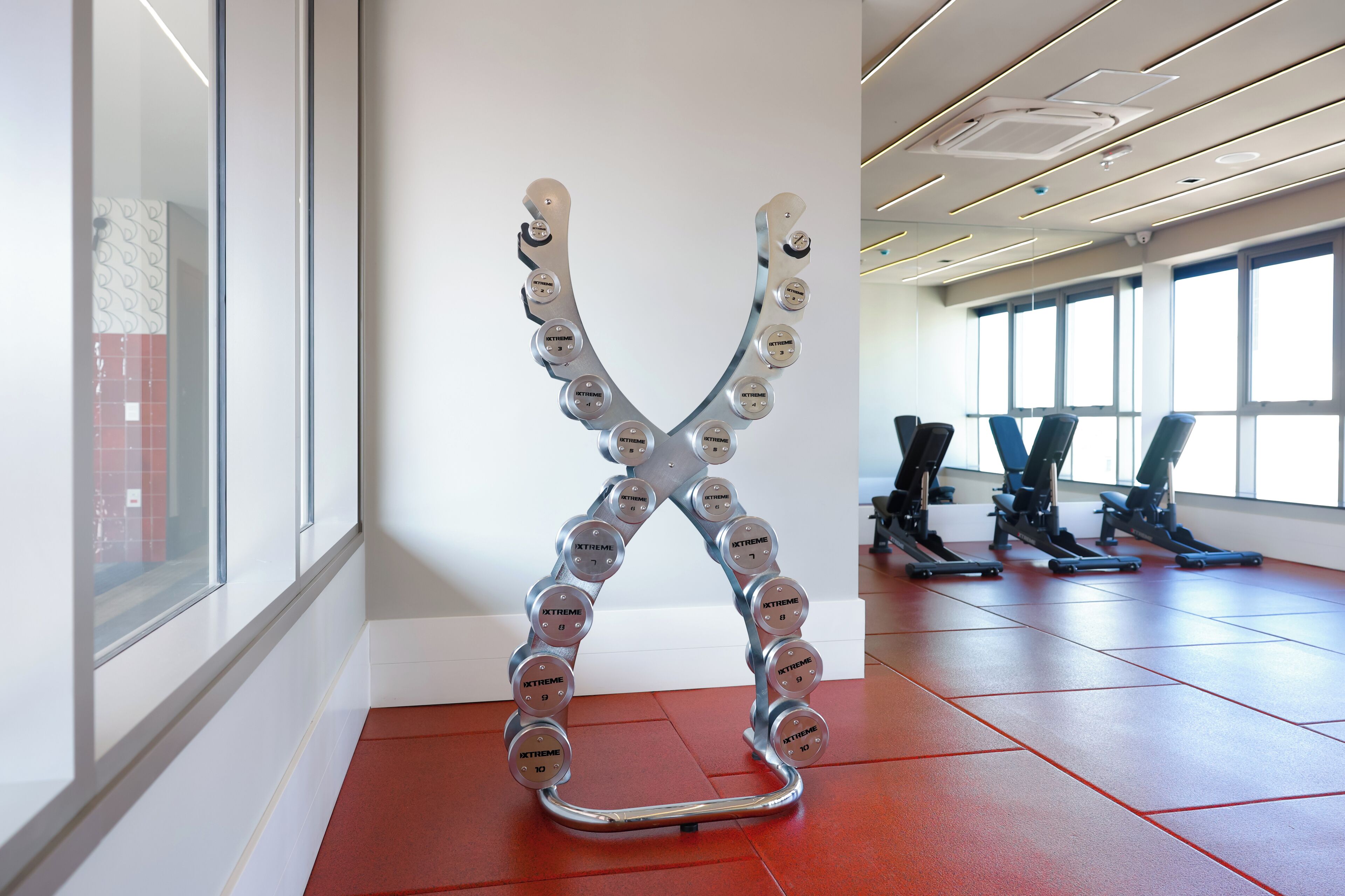 Et fitnesscenter med træningsudstyr og en unik metalkunst.