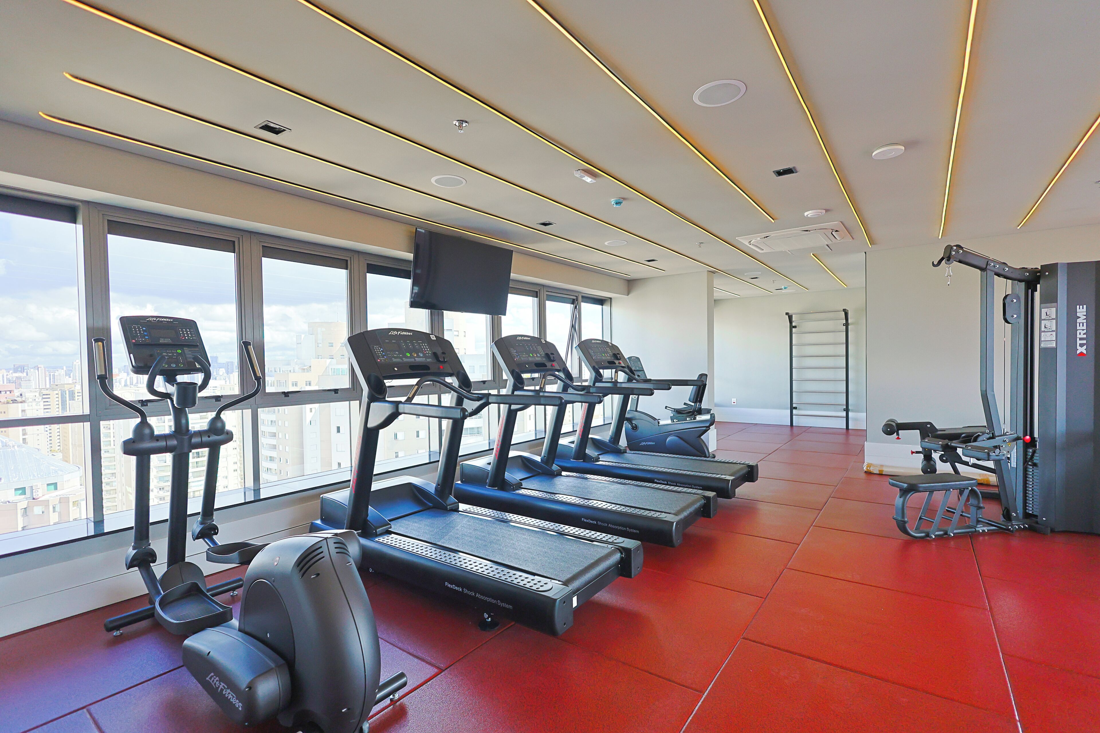 A gym with treadmills, a stationary bike, and a rowing machine.