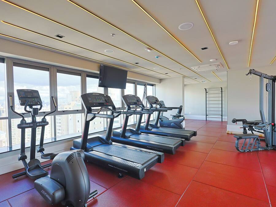 A gym with treadmills, a stationary bike, and a rowing machine.