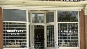 En butiksvisning af Highlands Liquor med store vinduer, der viser et udvalg af flasker.