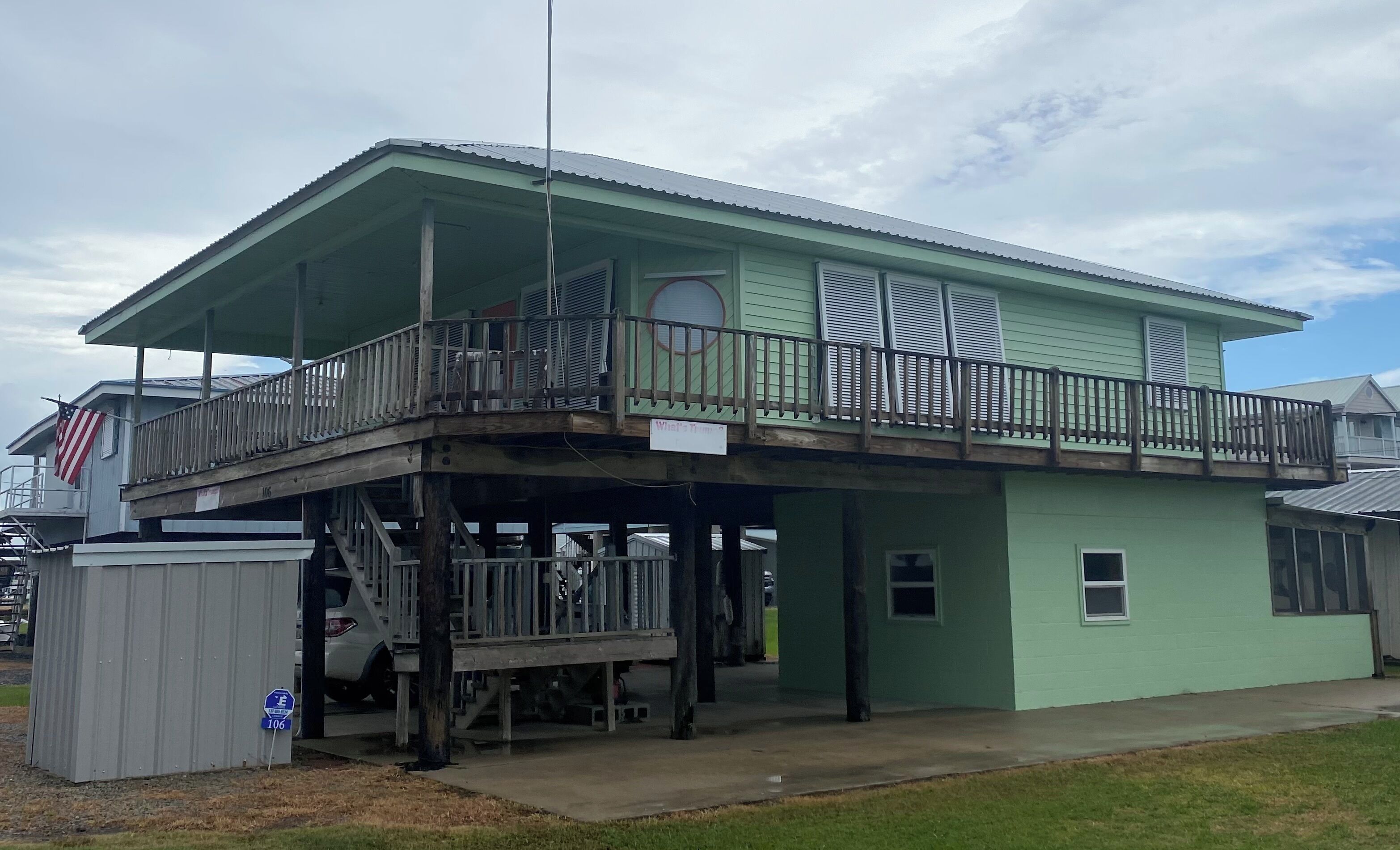 A two-story building with a balcony, a covered area, and a small attached garage.