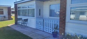Ein eingeschossiges Haus mit Garage, umzäunter Terrasse und kleinem Garten mit Narzissen.
