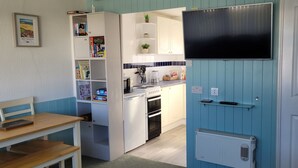 A compact kitchen with white cabinets, a built-in oven, and a microwave.