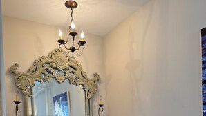 A room with a large ornate mirror, a chandelier, and a wooden floor. - Luxury Lodging, Lakefront View, King Bed w/Private Bath, Private Patio. (Elizabethtown)