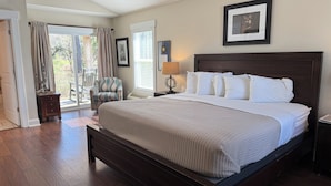A spacious bedroom with a large bed, a chair, and a nightstand. - Luxury Lodging, Lakefront View ,King Bed w/Private Bath, Private Patio. (Elizabethtown)