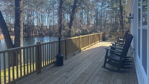 A wooden deck with a railing overlooking a body of water and trees. - Luxury Lodging, Lakefront View,  3-bedroom, 3.5 bath, sleeps 10, wrap-around patio. (Elizabethtown)