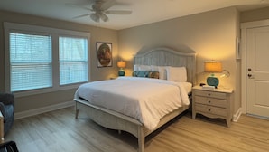 A bedroom with a bed, two bedside tables, a ceiling fan, and a window with blinds. - Luxury Lodging, Lakefront View,  3-bedroom, 3.5 bath, sleeps 10, wrap-around patio. (Elizabethtown)