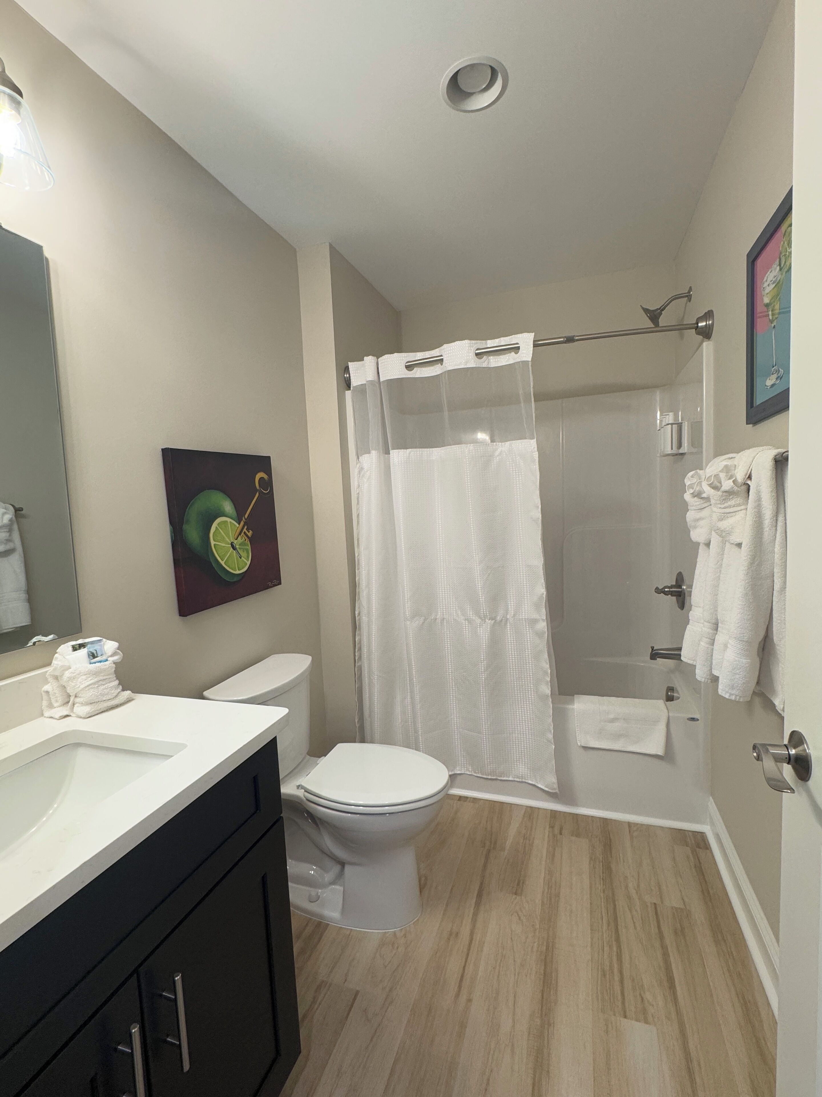 A bathroom with a toilet, sink, and shower area.