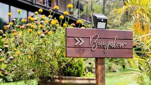 A wooden sign with "Bungalow" and "SAUNA ENTRANCE" indicating a bungalow area with a sauna. - Villa Ahó (Valle de Bravo)