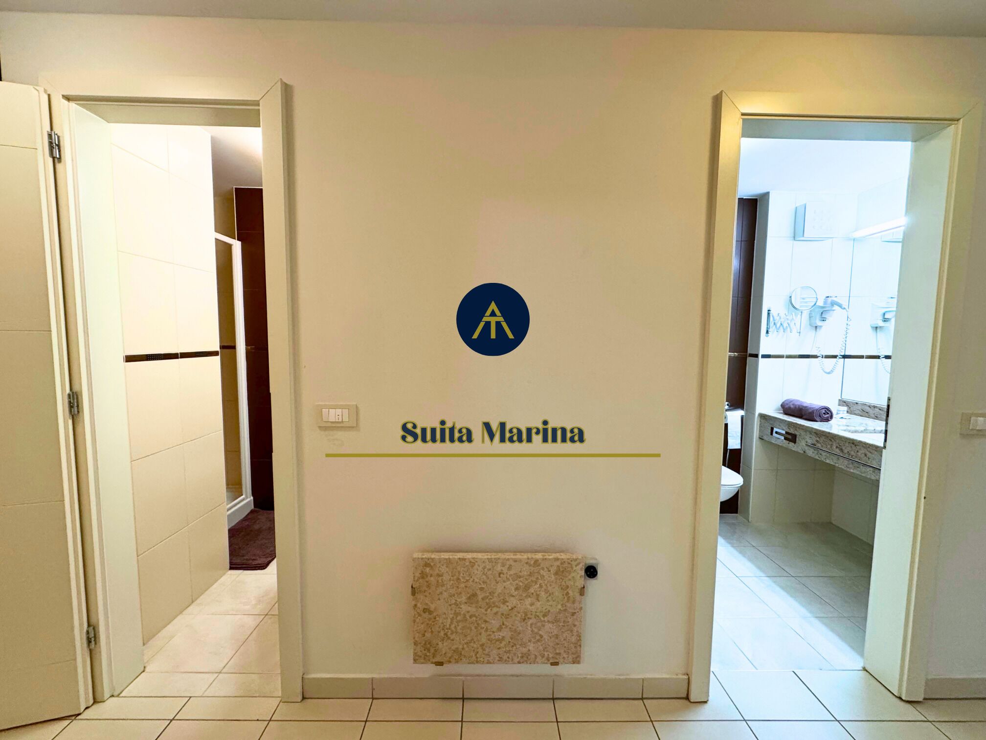 Un corridoio con un cartello che riporta la scritta 'Suita Marina' e un termosifone.