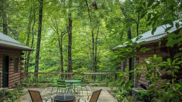 Une cabane dotée d’une terrasse, d’un espace salon extérieur et d’un foyer.