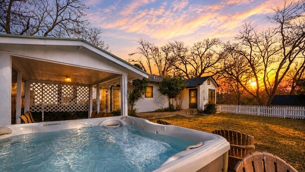 A hot tub in a backyard with a house and trees. - Leicht Haus Hot-tub & Fire Pit, 5 Blks to Marktplatz! (Fredericksburg)