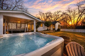 Un jacuzzi dans un jardin, avec une maison et des arbres.