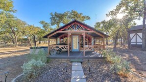 A small, single-story building with a porch and a door, surrounded by trees and a clear sky. - The Vines Retreat, Hot-tubs, Game Room, 10-mins to Downtown! (Fredericksburg)