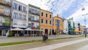 A street with buildings, including a restaurant named "Portuguese Sardine" and a sign for "The Fantastic World of the Casa Portuguesa".
