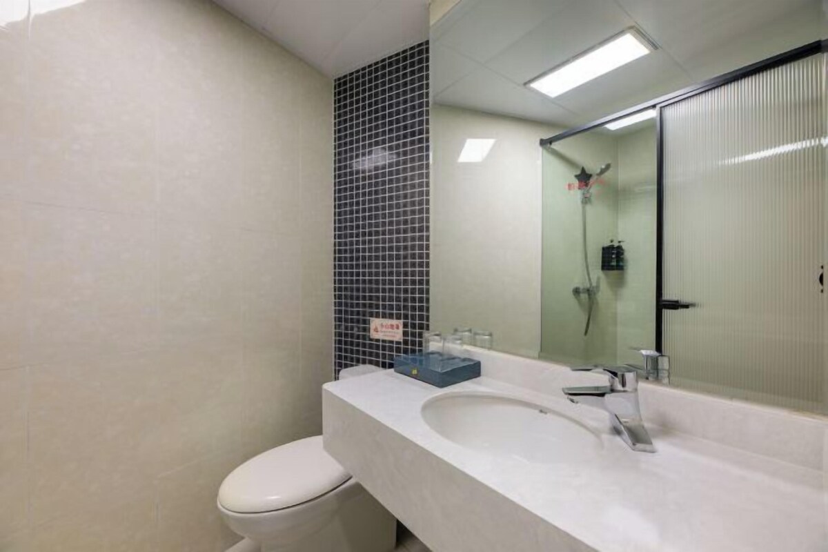 Ein Badezimmer mit einem weißen Waschbecken, einem Spiegel und einer Toilette.