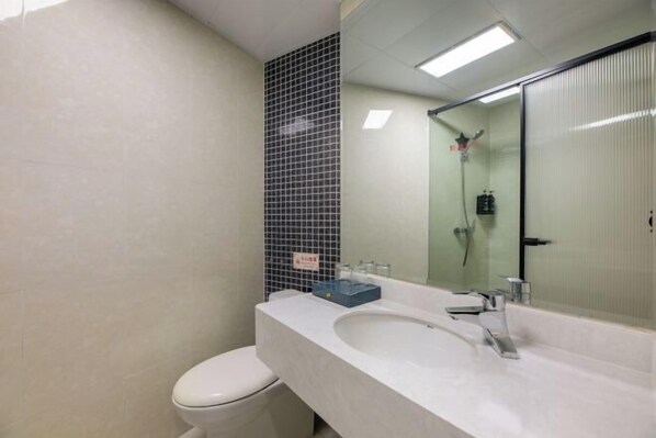 Un bagno con un lavandino bianco, uno specchio e un water.
