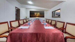A conference room with a long table, chairs, and a large screen displaying text. - City 118 Old Street Binjiang Road (Huangshan City)