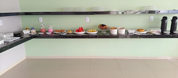 Una barra de buffet con diferentes alimentos y bebidas.