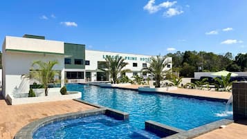 Una piscina al aire libre, sillones reclinables de piscina