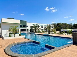 Una piscina al aire libre, sillones reclinables de piscina