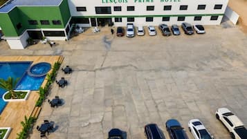 Un hotel con piscina, mobiliario exterior y aparcamiento.