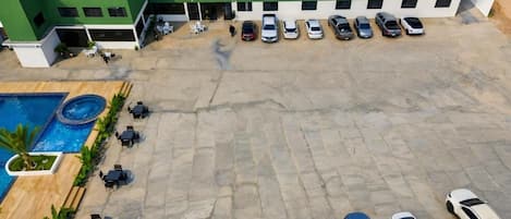 Un hotel con piscina, mobiliario exterior y aparcamiento.