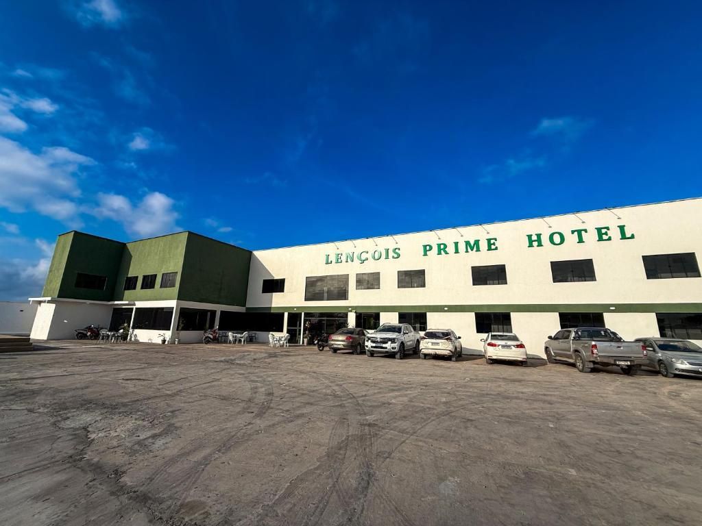Um hotel com fachada plana, vários espaços de estacionamento e céu claro.