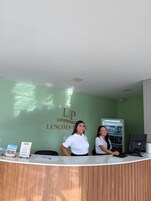 Una mesa de recepción con una pared verde y un letrero que dice 'LENCÔIS LOBOS'.