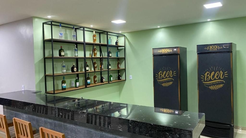 A bar area with a glass counter, shelves with bottles, and two refrigerators labeled 'Beer'.