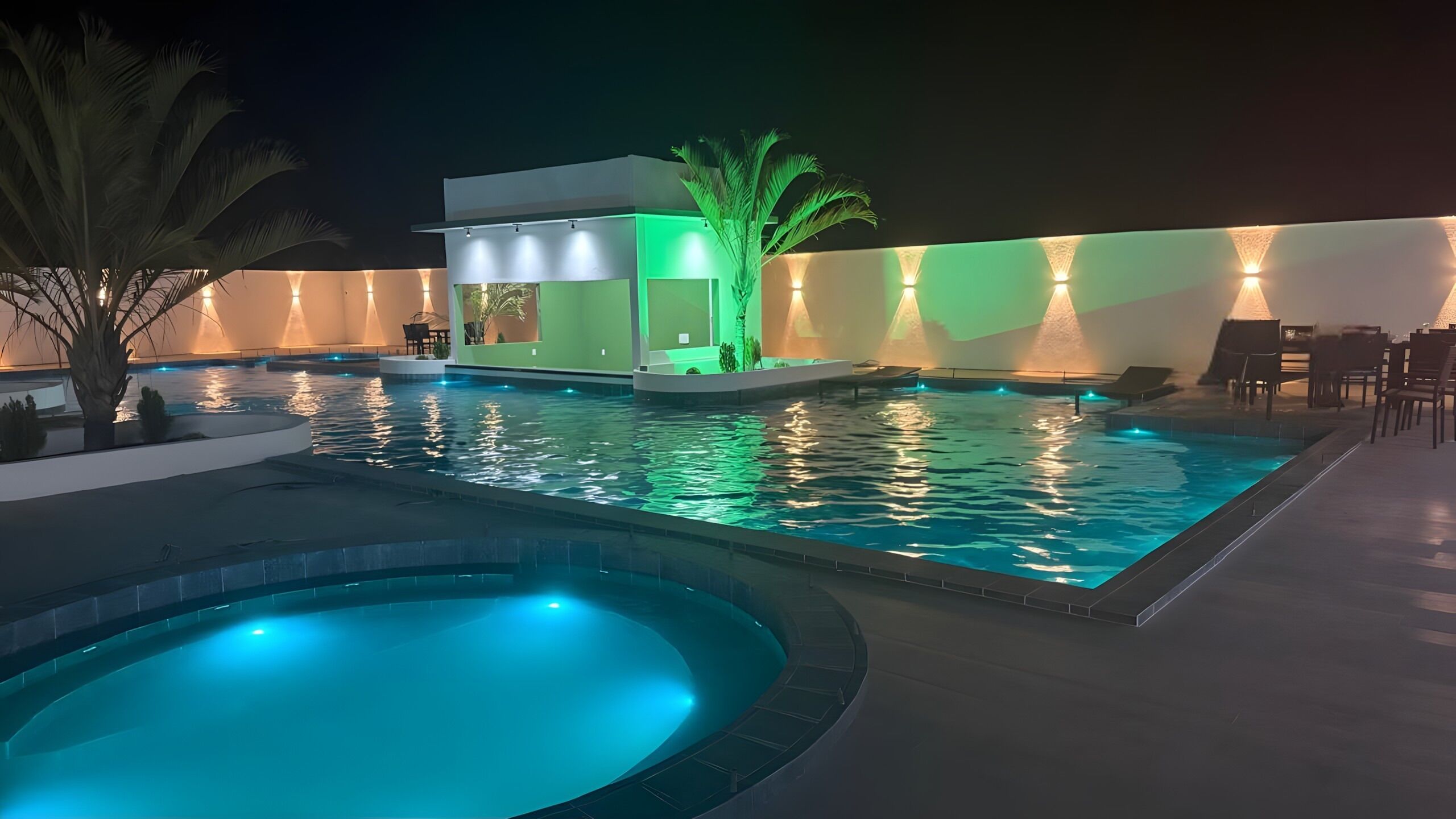 Una piscina al aire libre, sillones reclinables de piscina