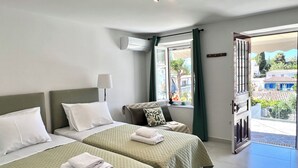 Habitación de hotel con dos camas, una ventana con cortinas, una lámpara y vistas al exterior.