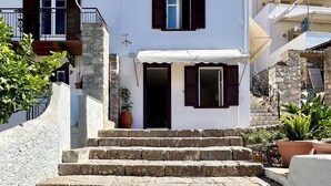 Un edificio de dos pisos con escalones de piedra que conducen a la entrada.