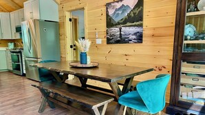 Een houten interieur met een eettafel, bankjes en stoelen.