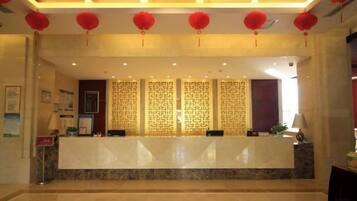 A reception area with a marble counter, red lanterns, and patterned wall decorations.