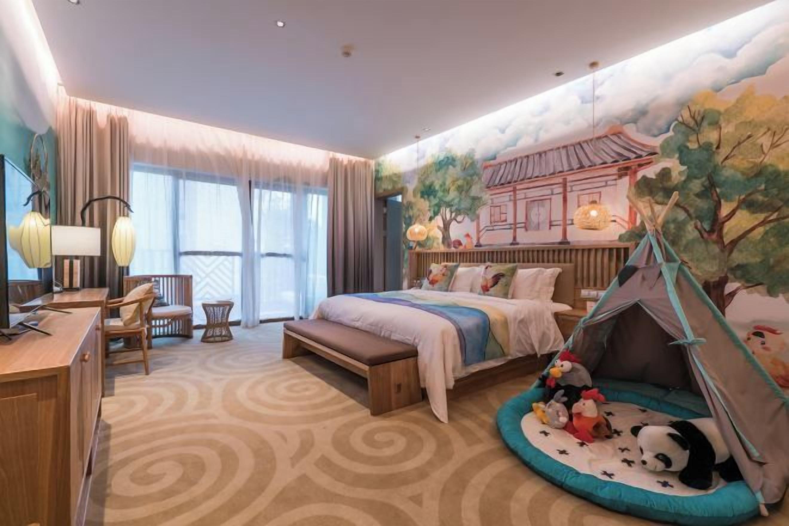 Habitación de hotel con cama, escritorio, silla, ventana y un mural.