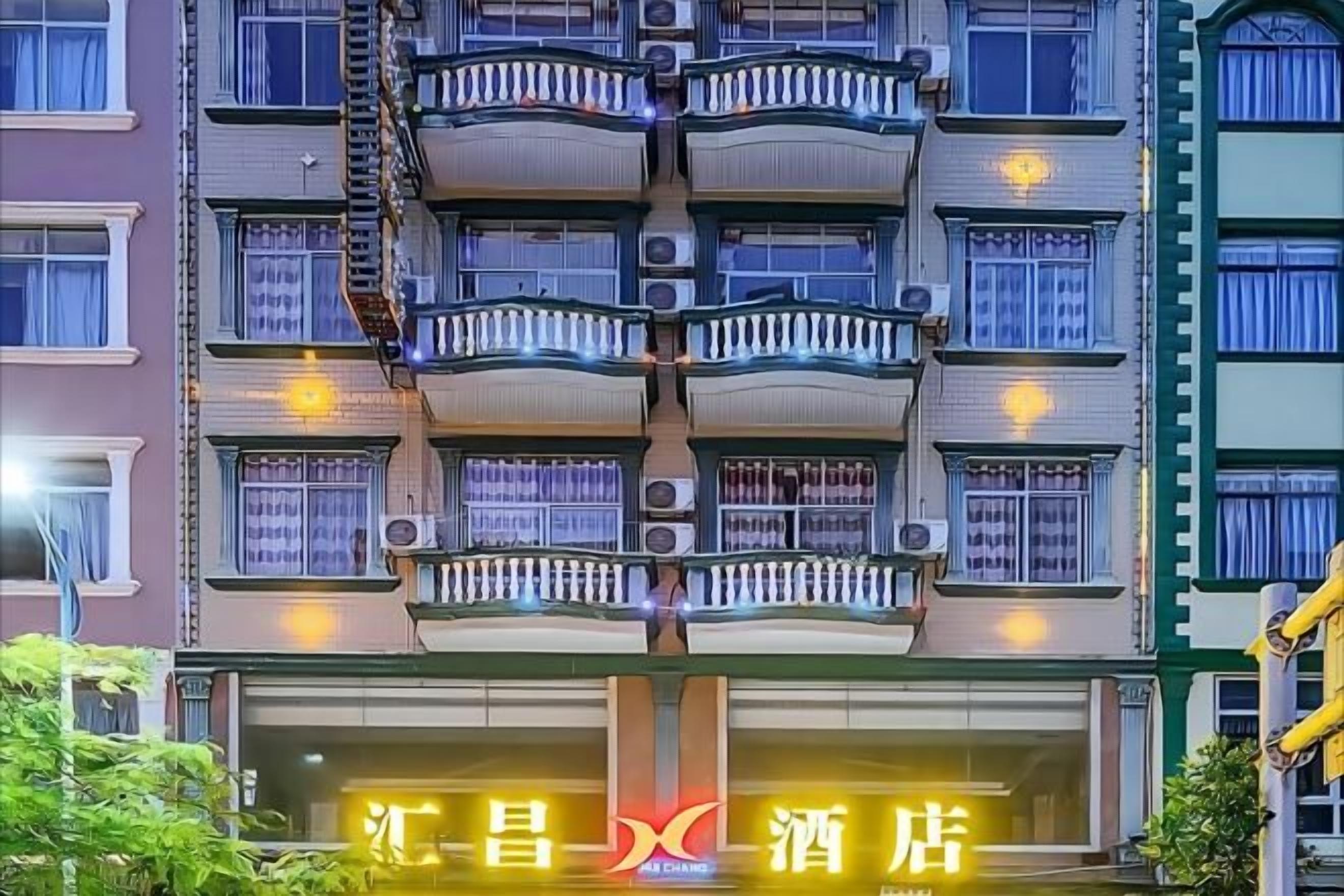 A multi-story hotel with balconies and a sign indicating it is a hotel.