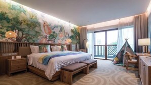 A bedroom with a large bed, a bench, a desk, a chair, a window, and a mural on the wall. - Dongxing Huichang Fashion Hotel (Dongxing)