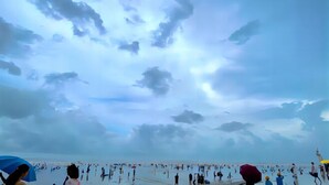 A beach scene with people and umbrellas. - Dongxing Huichang Fashion Hotel (Dongxing)