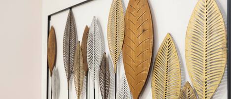 A wall with a series of decorative leaf-shaped metal pieces.