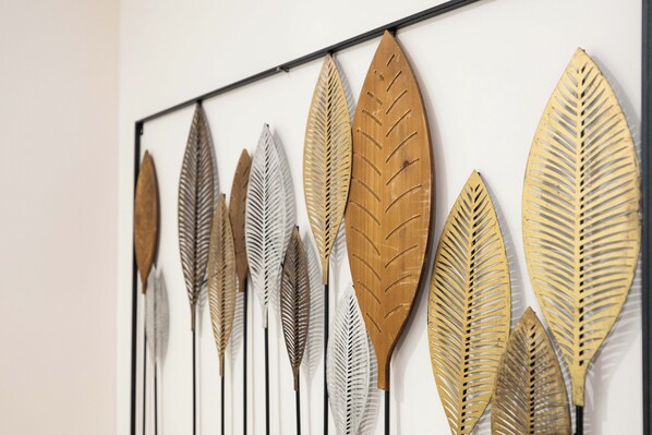 Una pared decorada con una serie de piezas metálicas con forma de hoja.