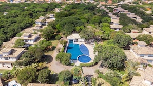 A resort with villas, a swimming pool, and a view of the sea.