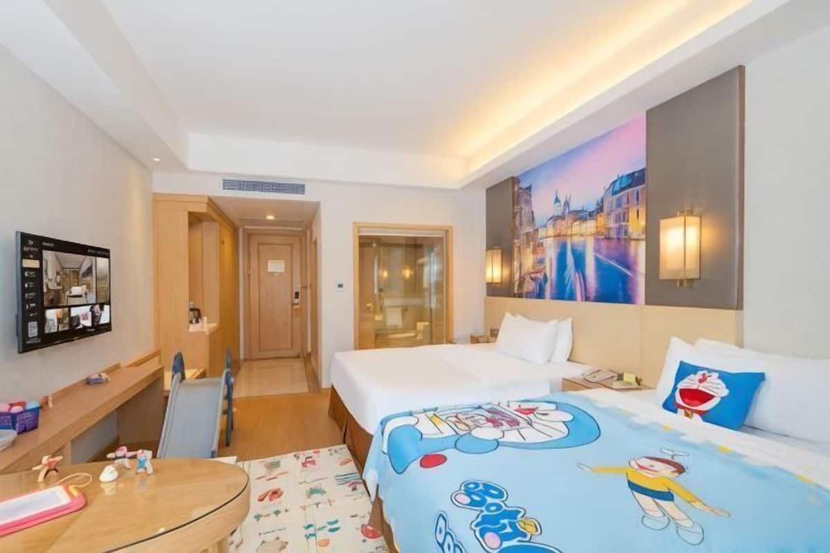 A hotel room with a bed, a desk, a chair, a TV, and a painting on the wall.