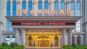 A grand hotel entrance with classical architecture, featuring large columns and arched windows. - Vienna International Hotel Zhanjiang North Railway Station Dingsheng Plaza (Zhanjiang)