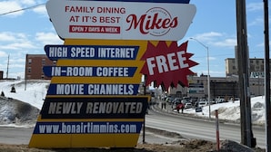 A large, colorful sign for Bon Air Motel advertising family dining, high-speed internet, in-room coffee, movie channels, and free Wi-Fi.