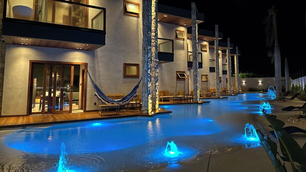 A modern resort with a swimming pool, stone pillars, and outdoor seating. - VILLA PRIME BEACH (ARACAJU)