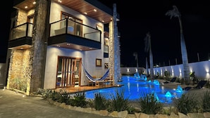 A modern two-story house with a swimming pool, stone walls, and a hammock. - VILLA PRIME BEACH (ARACAJU)
