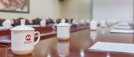 A conference room with a long table, chairs, and a whiteboard.