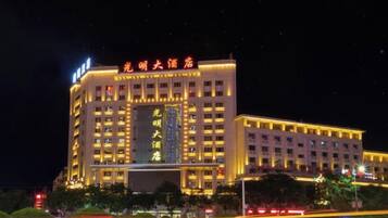 Un hotel a più piani con insegne illuminate e un ingresso ben visibile.