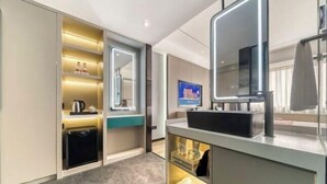 A modern bathroom with a vanity, mirror, and built-in shelves. - Guangming Hotel (Jiuquan)